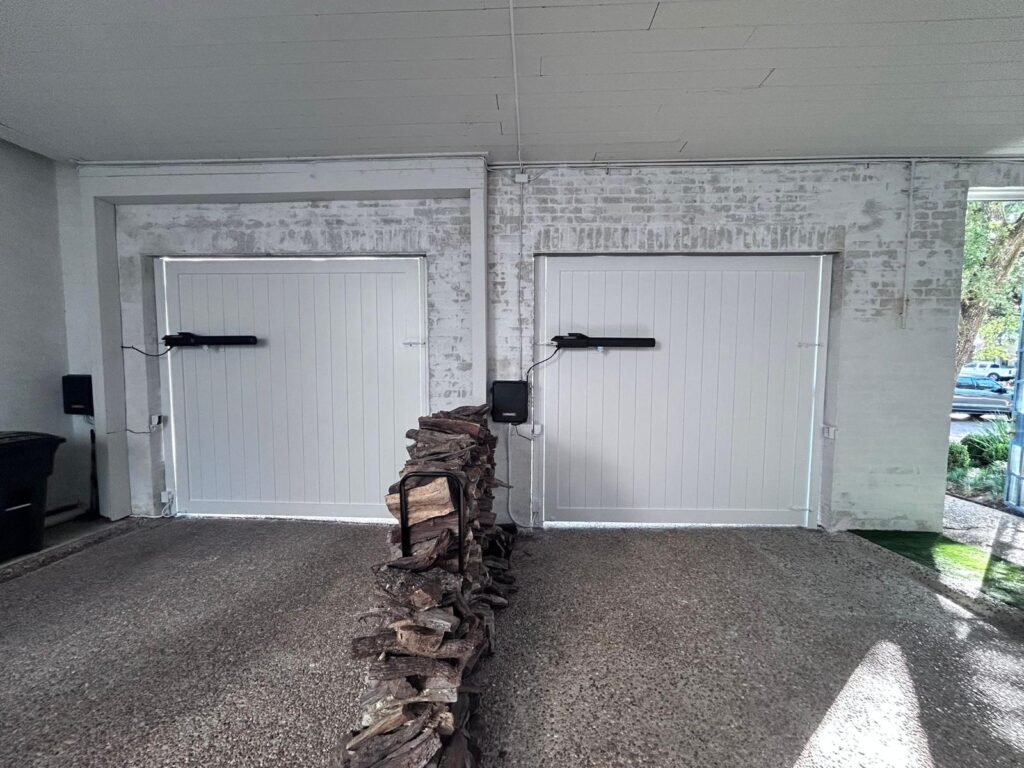 White carriage-style swing garage doors automated with LiftMaster swing door operators
