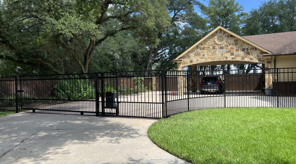 Iron sliding driveway gate at a residential home with a curved drive