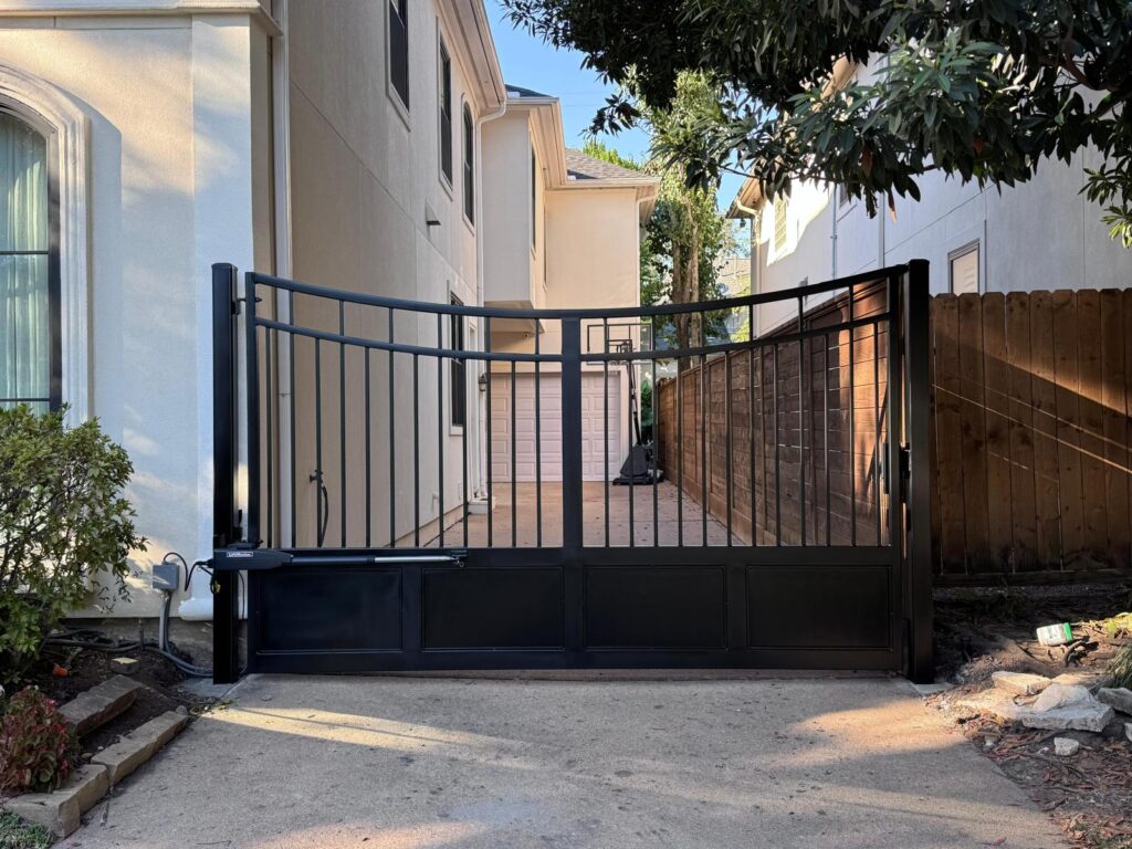 Arched iron driveway gate with solid lower panels and LiftMaster linear arm operator installed