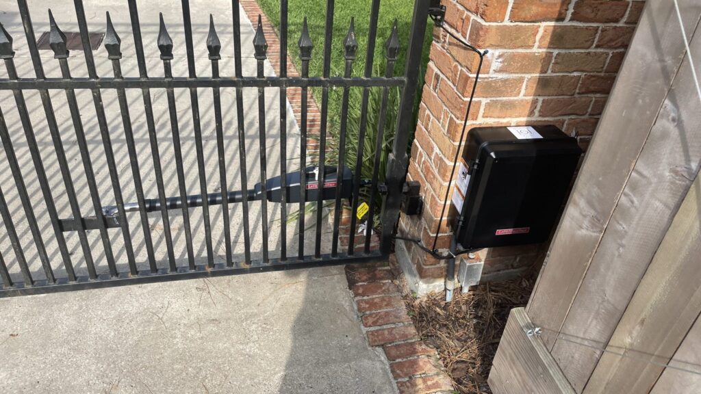 LiftMaster LA400 operator and control box mounted at a brick column beside an iron gate