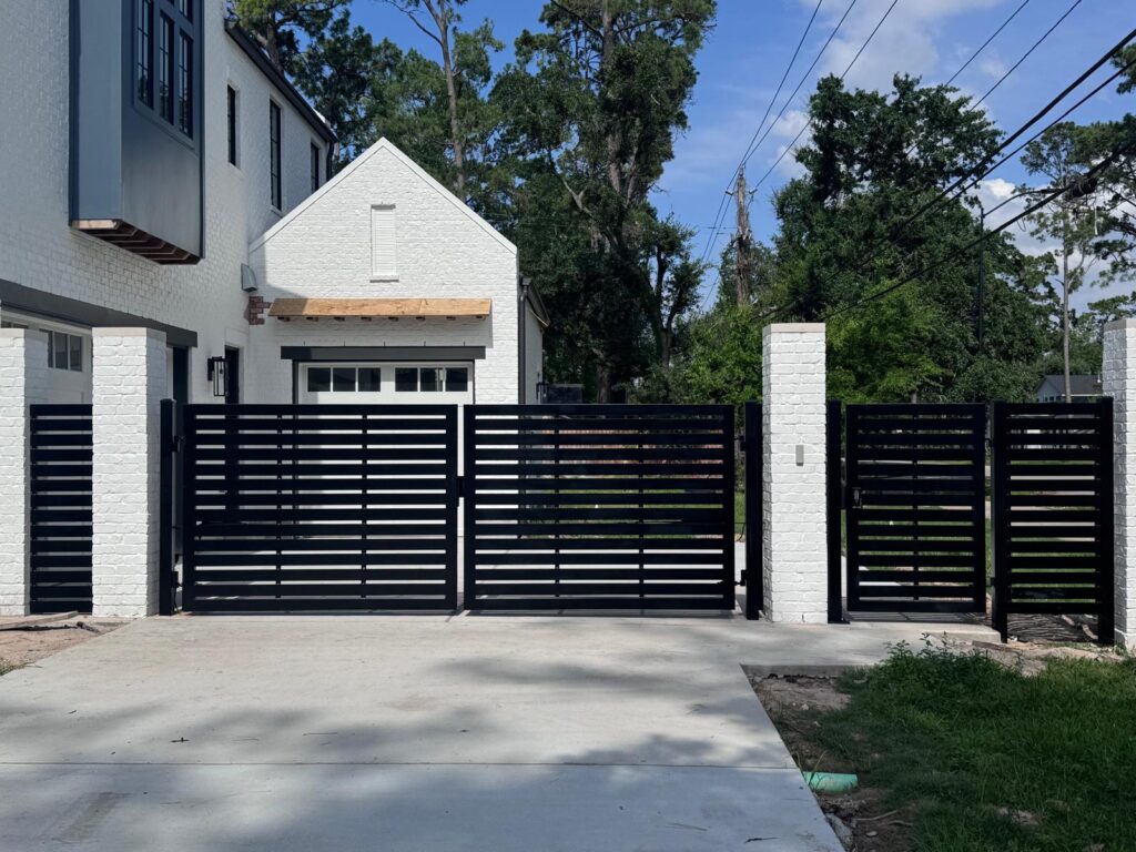 Horizontal-slat steel double swing gate with matching pedestrian gate and fence panels, installed in Sugar Land, TX