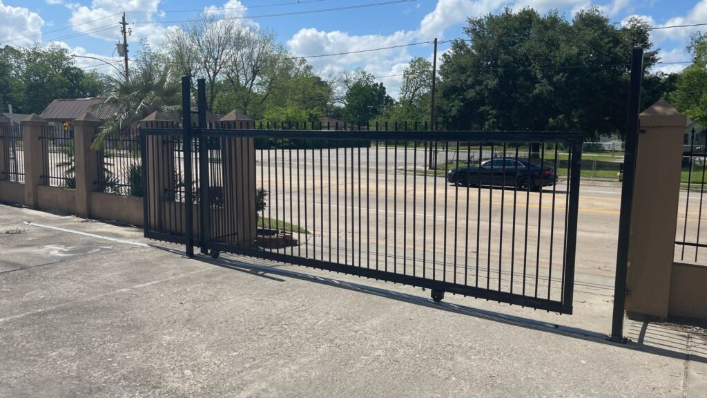 Commercial iron slide gate across a parking lot entrance in Baytown, TX