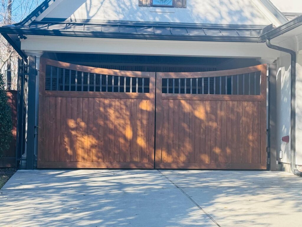 Stained wood double gate with arched spindle top under a porte-cochere